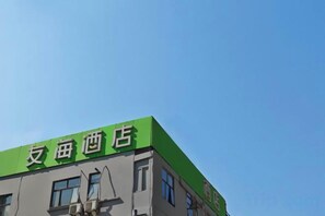Um edifício com telhado verde e uma placa que diz '友海酒店' (Yufei Hotel).