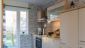 Una cocina con pared de ladrillo, puerta corredera de vidrio y estufa moderna.