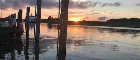 Una masa de agua tranquila con barcos amarrados y postes de madera.