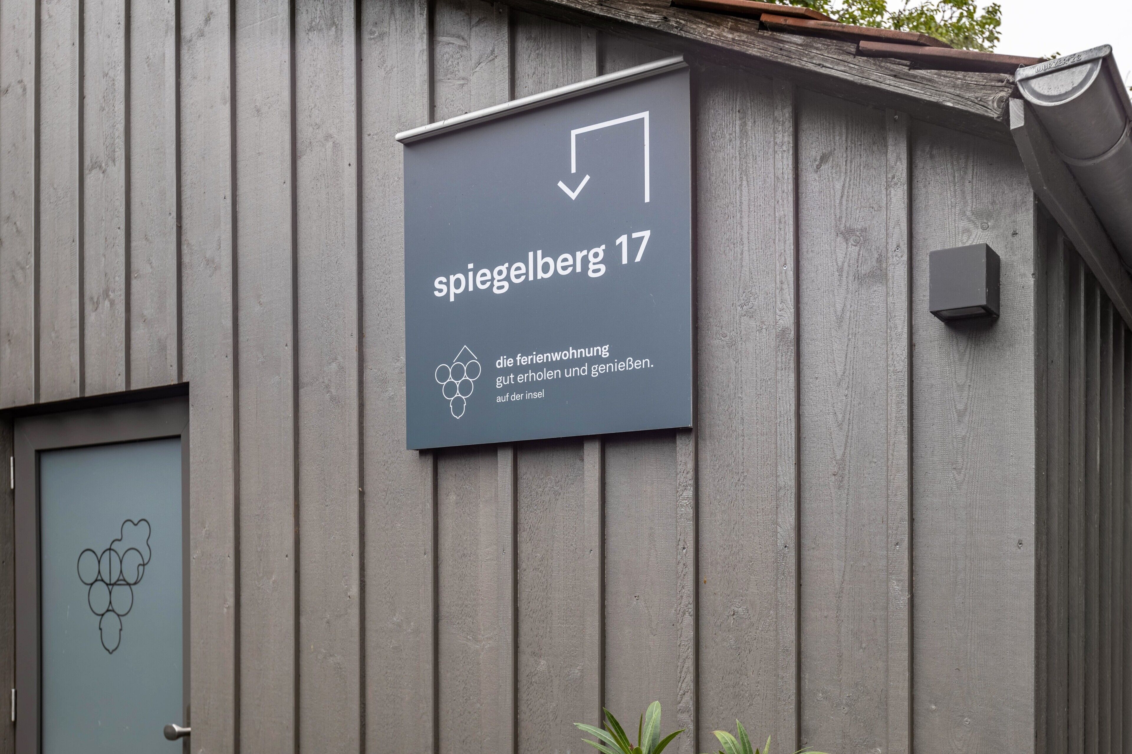 Ein Gebäude mit einem Schild, das 'Spiegelberg 17' zeigt, und einem Symbol eines Hauses mit Weinrebe.