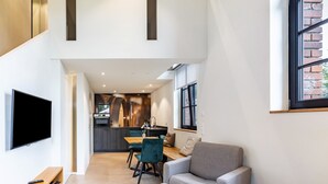 Un interior moderno con televisor, zona de estar, cocina y ventana con vistas.