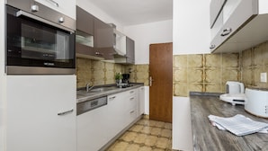 A modern kitchen with white cabinets, a built-in oven, a coffee maker, and a toaster. - House Rose With Private Pool And Garden (Krk)