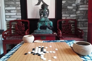 A Go board with pieces in play, a statue, and traditional chairs. - Jinshidi Inn (Guangzhou)