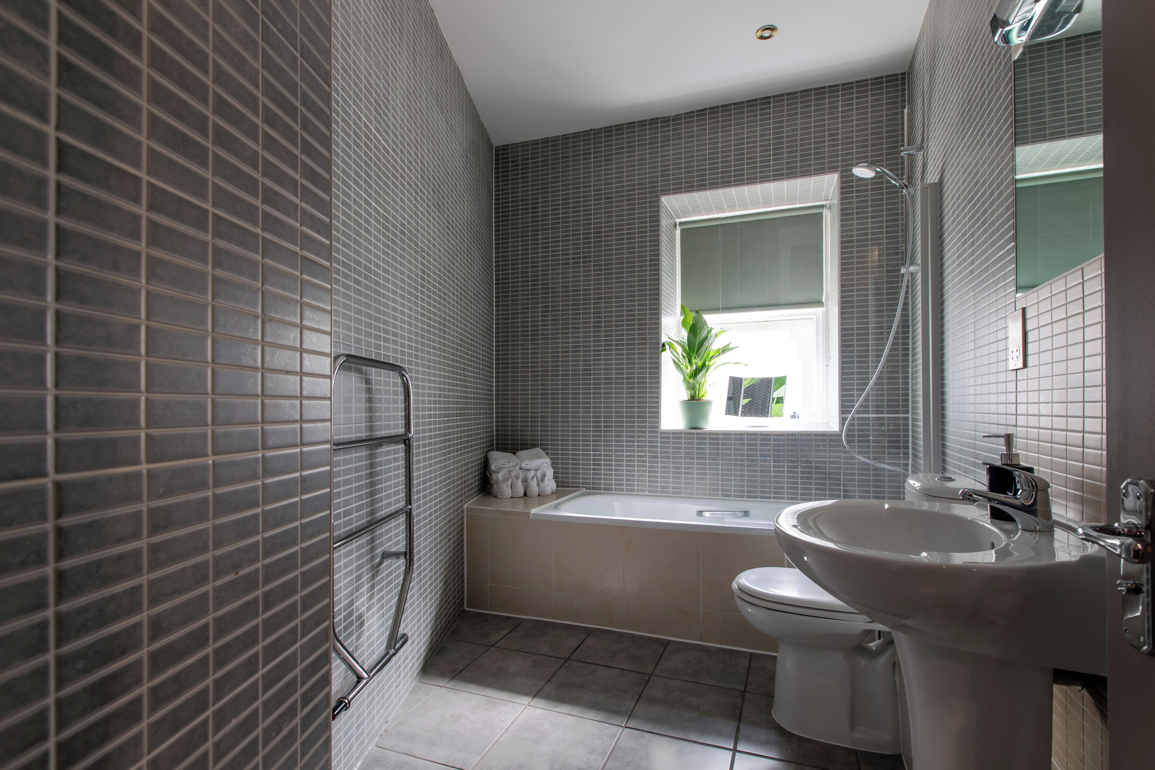 A modern bathroom with a bathtub, toilet, and sink.