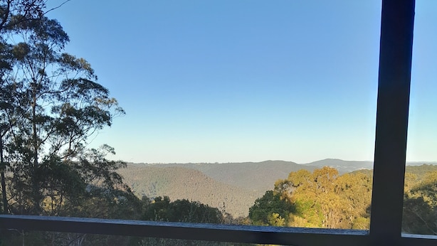 Une pièce dotée d’une grande fenêtre donnant sur un paysage boisé.