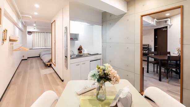 Une chambre d’hôtel moderne dotée d’un coin repas, d’une cuisine et d’une salle de bain.