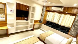 A hotel room with two beds, a TV, a wardrobe, and an air conditioning unit. - Hotel BKC Prime  (Mumbai)