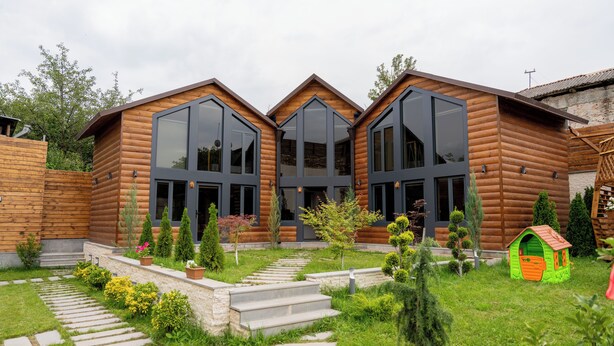 A log cabin with large windows, a stone pathway, and a small playhouse. - Taniqinn Dilijan Cottages  (Dilijan)