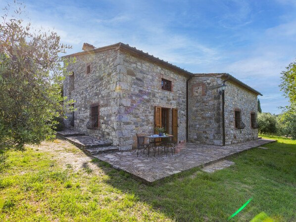 A stone building with a patio and outdoor seating area.