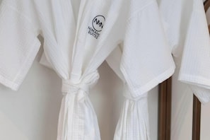 A white robe with a logo and text on it.