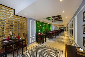 A hotel lobby with a long corridor, a green wall with plants, and a decorative golden wall. - 22land 71 Hang Bong Hotel (Hanoi)