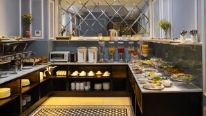 Un bufé de desayuno con diversas opciones de comida y una estación de café.