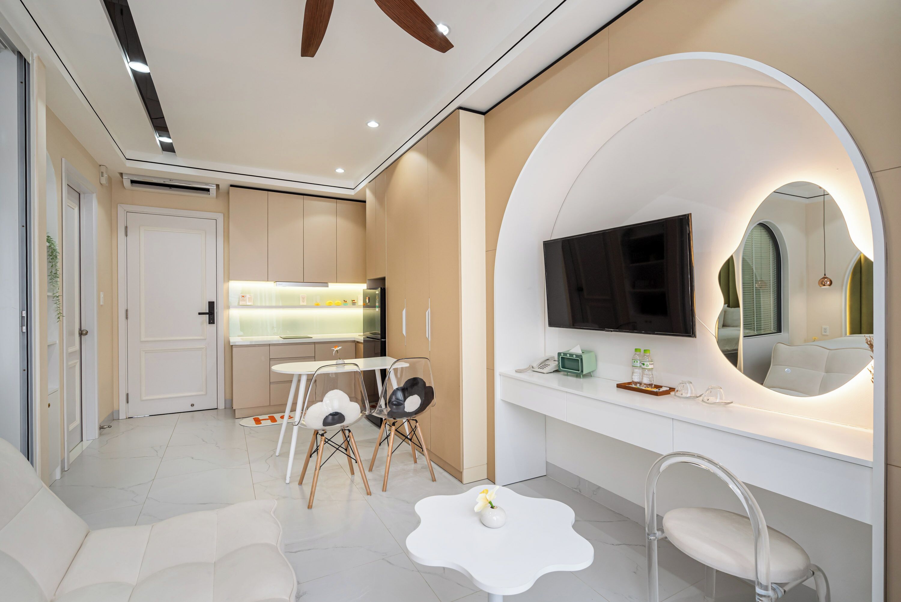 A modern hotel room with a living area, a dining table, and a large mirror.
