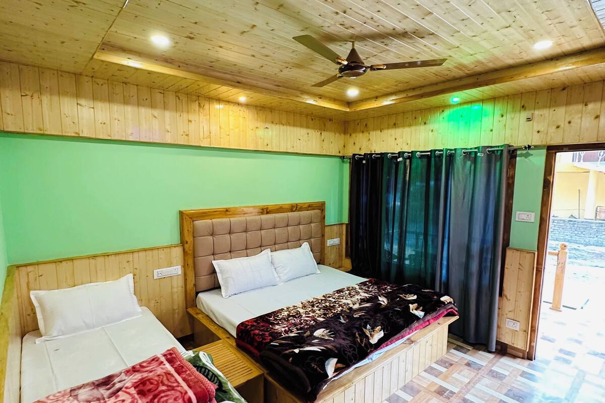 A room with two beds, a ceiling fan, and a patterned floor.