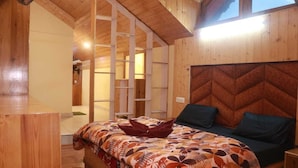 A wooden cabin bedroom with a bed, a nightstand, and a built-in bench. - Pirates Of Parvati (Bhuntar)