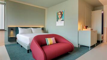 Une chambre à coucher moderne avec un lit, une chaise rouge, une commode blanche et une étagère fixée au mur.