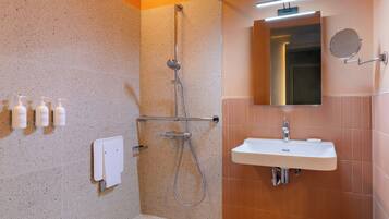 A modern bathroom with a shower, sink, and mirror.
