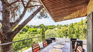 An outdoor patio with a table and chairs, overlooking a lush landscape.