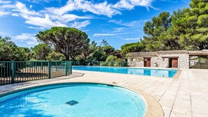 Una piscina con un edificio de piedra al fondo.