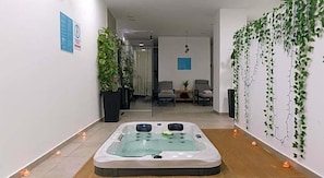 A spa area with a hot tub, potted plants, and seating. - Caramela Luxury Apartments (Ayia Napa)