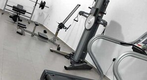 A gym with various exercise equipment including treadmills, weight machines, and free weights. - Caramela Luxury Apartments (Ayia Napa)