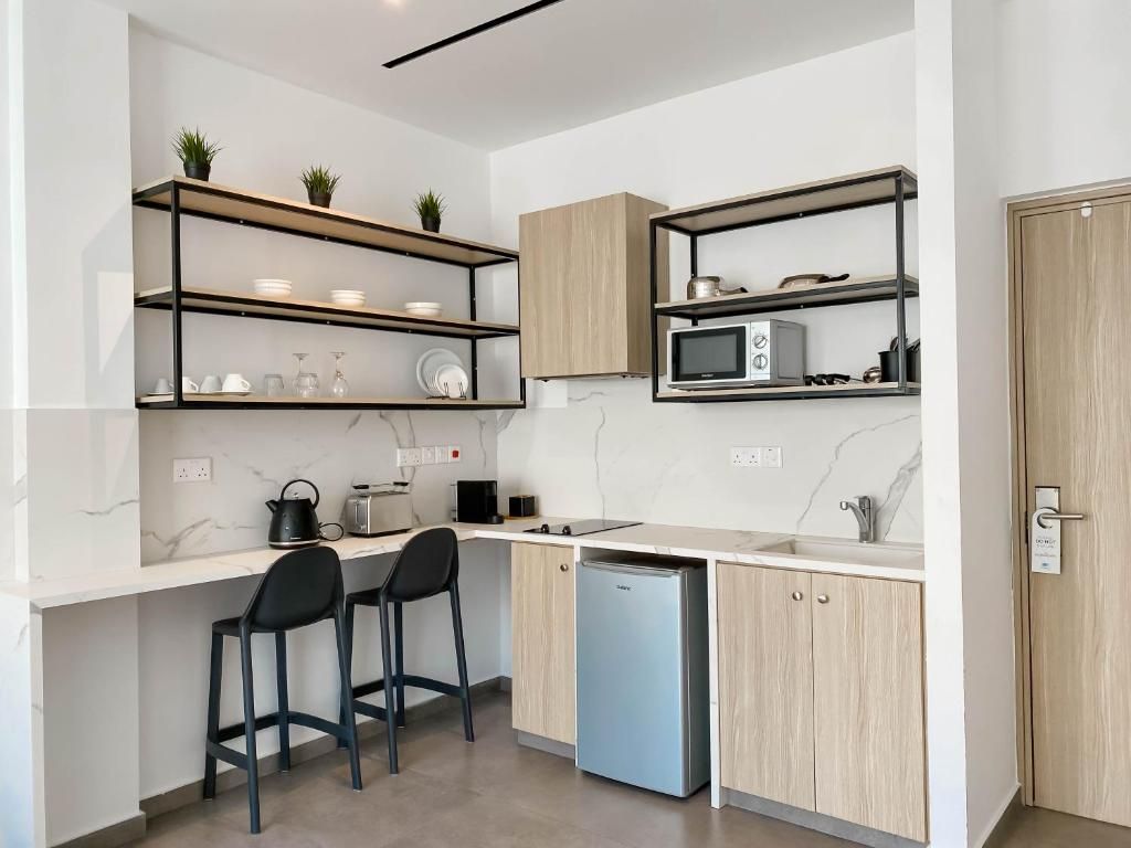 Una cocina moderna con electrodomésticos integrados, armarios de madera y una encimera con taburetes de bar.