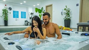 A couple in a hot tub with a fitness machine in the background. - Caramela Luxury Apartments (Ayia Napa)