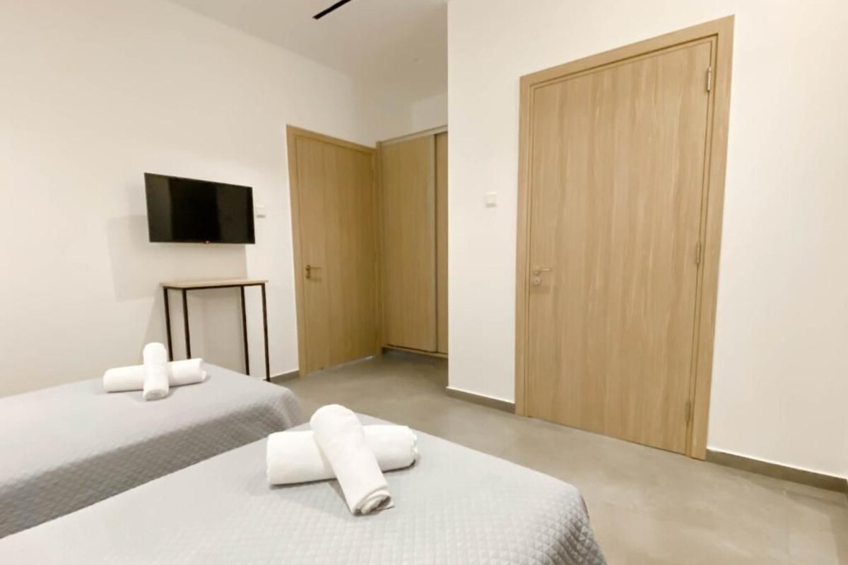 Een hotelkamer met twee bedden, een televisie en houten kasten.