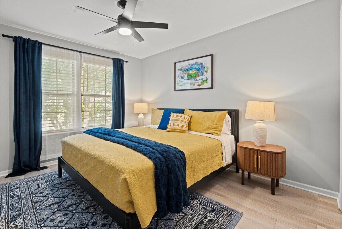 Second upper-level king bedroom with cozy linens, ceiling fan, and natural light for a calm and relaxing stay.