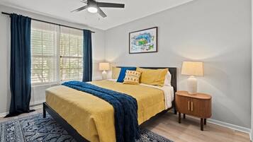 Second upper-level king bedroom with cozy linens, ceiling fan, and natural light for a calm and relaxing stay.