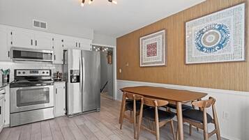 Modern stainless steel appliances paired with a comfortable dining setup for everyday use.