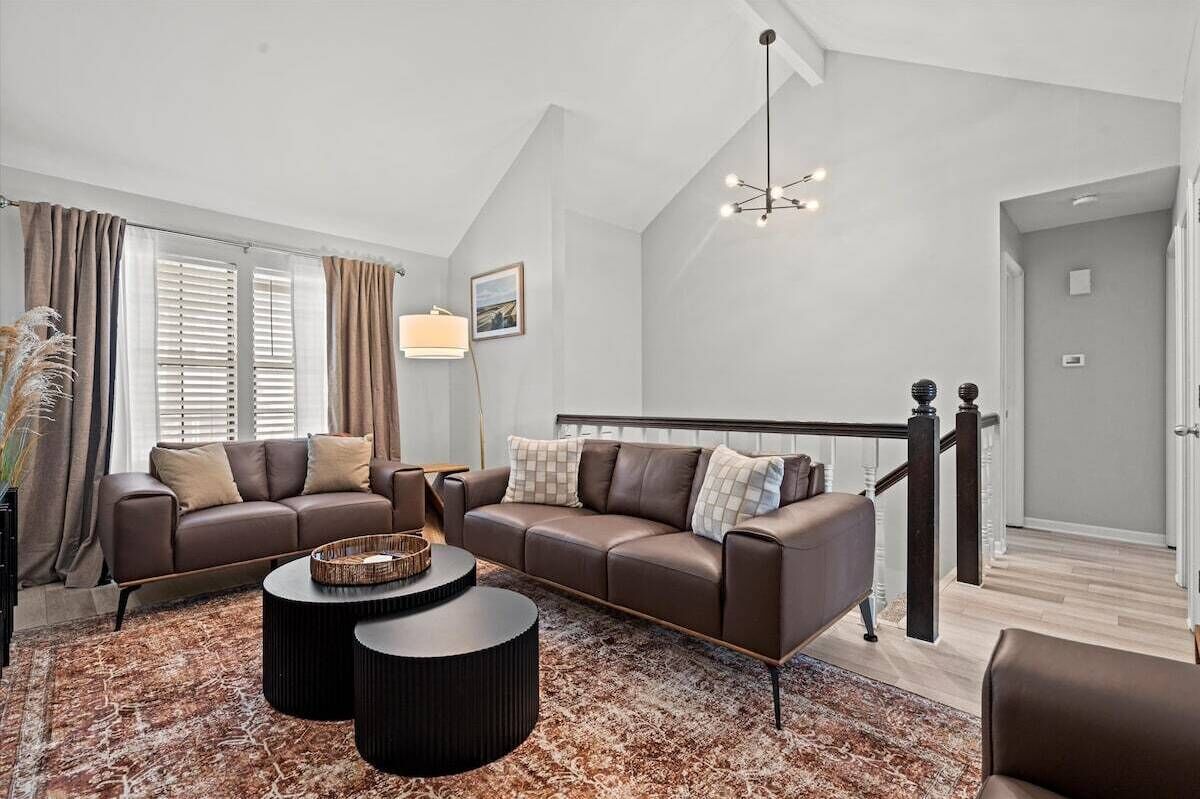 Elevated living room with plush sofas and natural light, offering a quiet retreat while still feeling connected to the home.