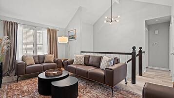Elevated living room with plush sofas and natural light, offering a quiet retreat while still feeling connected to the home.