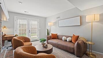 Comfortable lounge space with soft carpeting and access to the back porch, ideal for unwinding after exploring nearby Westwood Park or the Plaza.