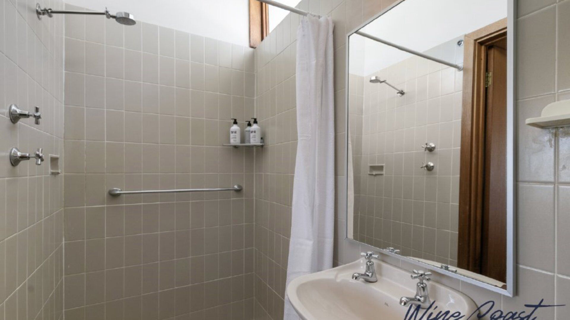 A bathroom with a shower, a sink, and a mirror.