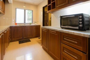 Réfrigérateur, un four, surface de cuisson, vaisselle et ustensiles