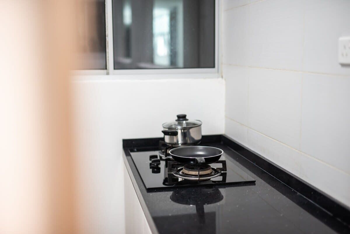 A kitchen with a gas stove, a pot, and a pan.