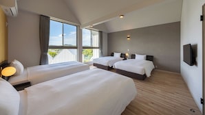 A modern hotel room with two beds, a large window with a view, a flat-screen TV mounted on the wall, and a ceiling fan. - Kanatanosato (Wakayama)