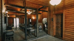 A rustic wooden interior with tables and chairs arranged for dining. - Kastel Konak Hotel (Surmene)