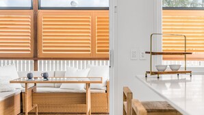 Una sala de estar moderna con un sofá, una mesa de centro y un comedor con un banco de madera y cuencos.
