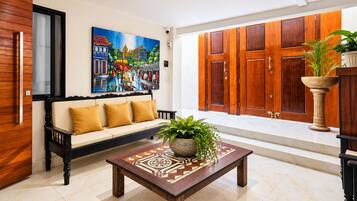 Uma sala de estar moderna com um sofá, uma mesa de centro e um quadro na parede.