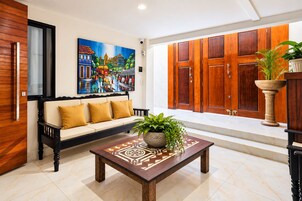 A modern living room with a sofa, a coffee table, and a painting on the wall.