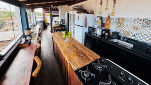 A kitchen with a wooden bar, black appliances, and a patterned backsplash. - Residence Pipa Beach (Tibau do Sul)