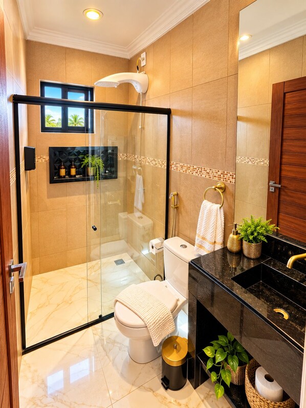 A modern bathroom with a glass-enclosed shower, a toilet, and a vanity with a black countertop. - Residence Pipa Beach (Tibau do Sul)