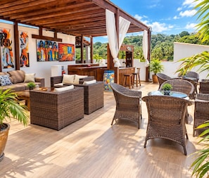 An outdoor patio with wicker furniture, a bar area, and artwork on the walls. - Residence Pipa Beach (Tibau do Sul)