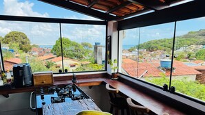A kitchen with a large window overlooking a residential area and the sea. - Residence Pipa Beach (Tibau do Sul)