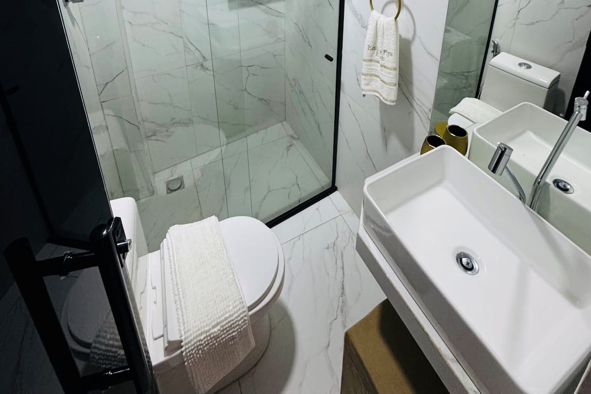 Quarto quádruplo superluxo, vista para o pátio | Banheiro | Chuveiro, chuveiro com efeito de chuva, secador de cabelo