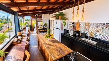 Cozinha moderna com bancada de madeira, geladeira e fogão.