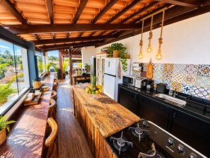 A modern kitchen with a wooden bar area, a refrigerator, and a stove. - Residence Pipa Beach (Tibau do Sul)
