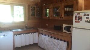 A kitchen with wooden cabinets, a microwave, and a refrigerator.